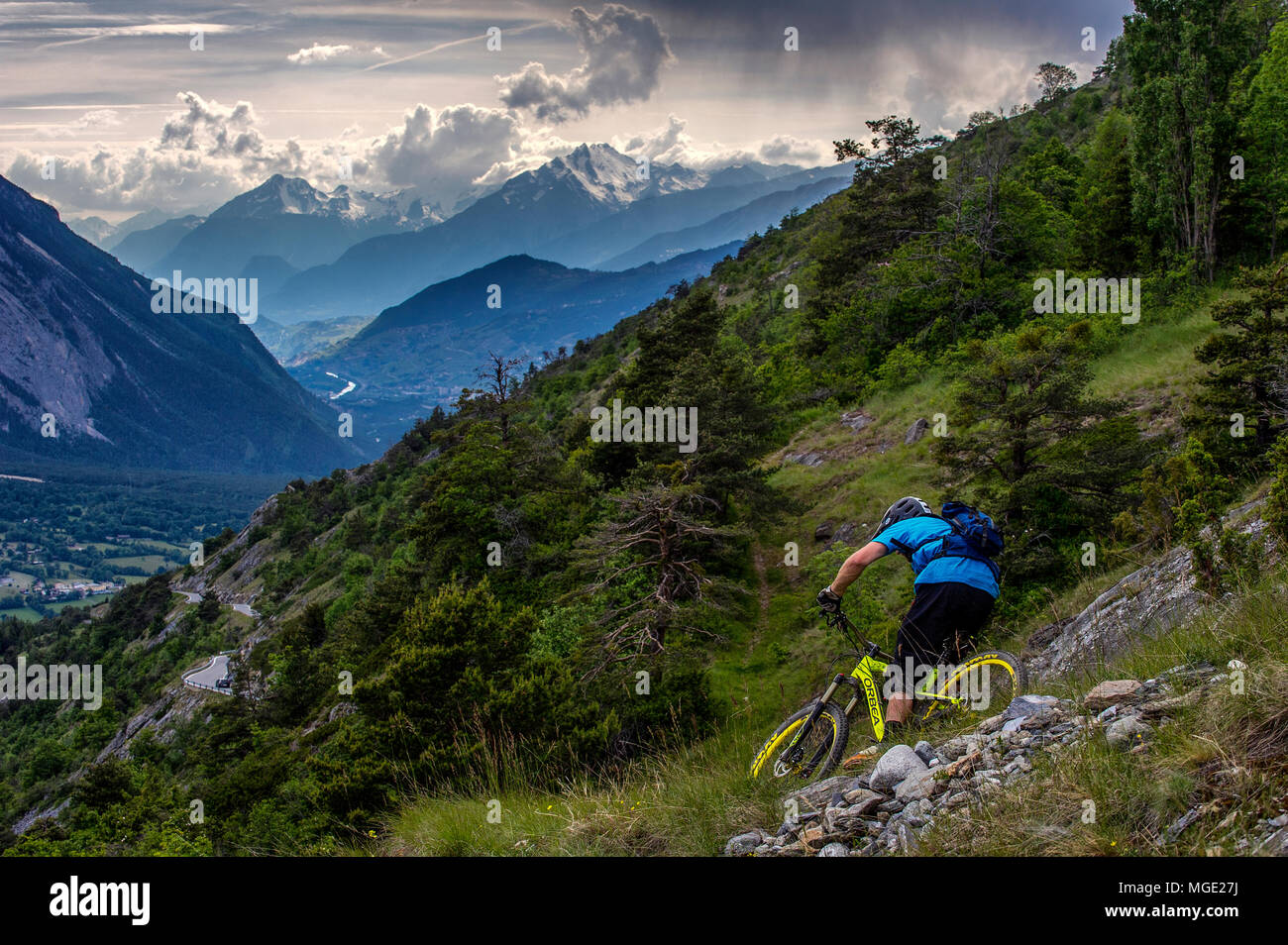Un homme monte un vtt haut au-dessus de la vallée, près des villes de Gampel et Jeizinen dans le Valais Suisse. Banque D'Images