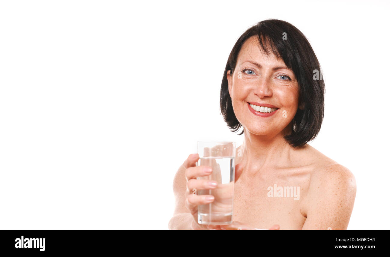 Femme mature maintenir le verre d'eau. Soins et Beauté concept Banque D'Images