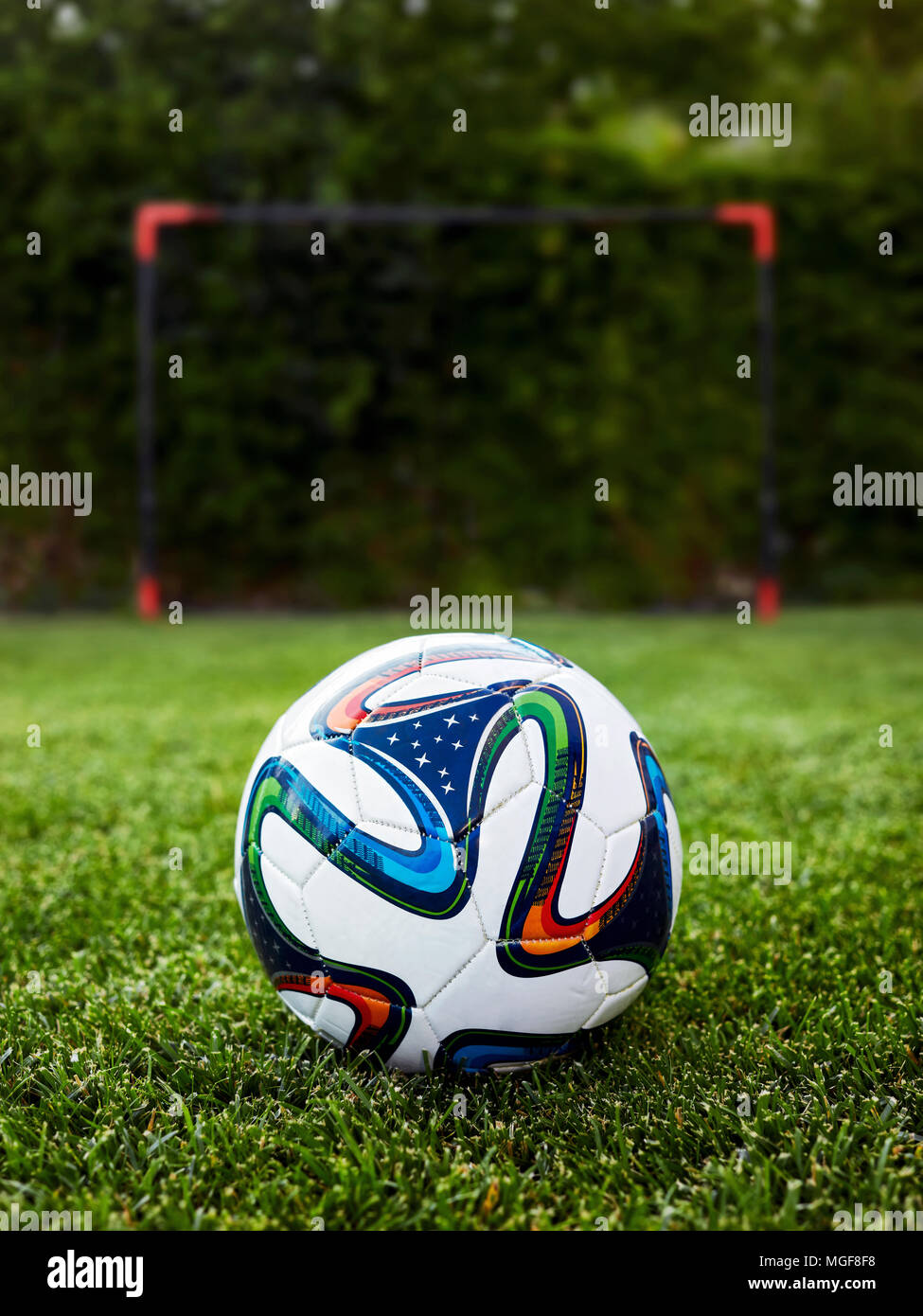 Ballon de football sur la pelouse en face d'un poteau de but Banque D'Images