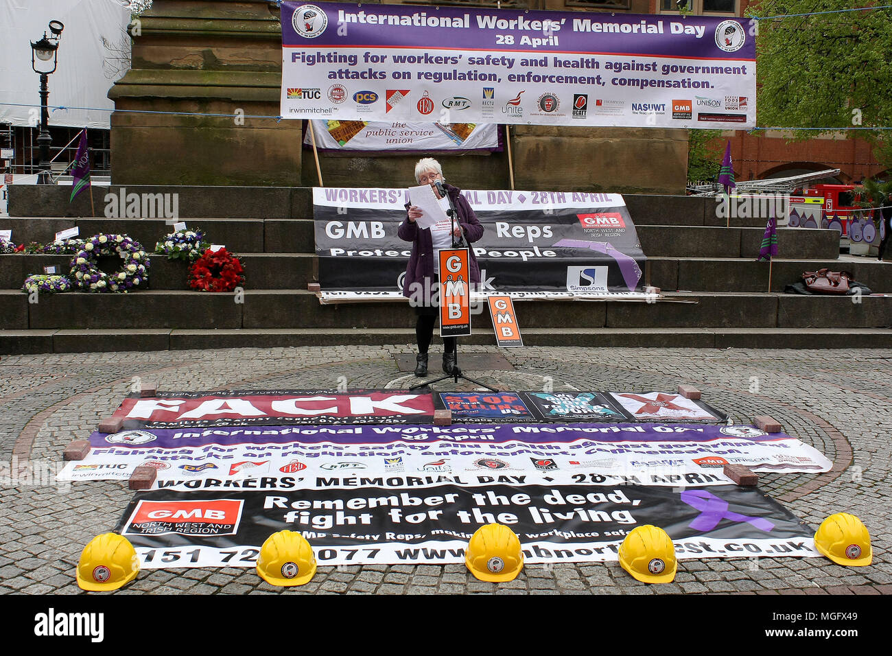 Manchester, UK. 28 avril 2018. Un parent d'un travailleur de la construction britannique décédé lit son histoire à la Journée internationale des travailleurs Memoriial rally dans le centre-ville de Manchester. Ce jour (28 avril) chaque année commémore tous les travailleurs tués, blessés ou devenus malades par le travail. Credit : SOPA/Alamy Images Limited Live News Banque D'Images