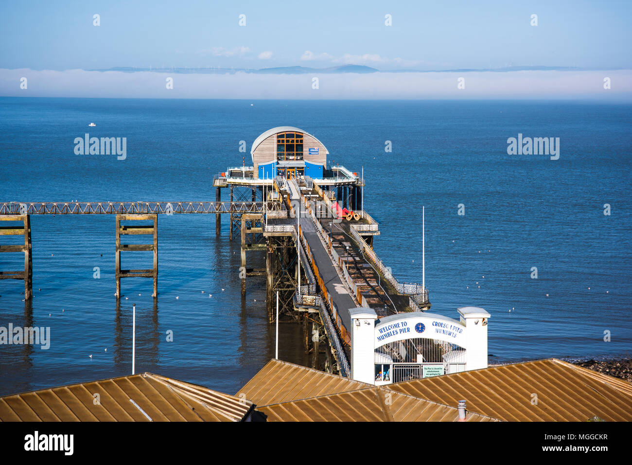 Seafog et la lumière du soleil dans la Baie de Swansea à Mumbles Pier et station de sauvetage, Mumbles, Swansea, Pays de Galles, Royaume-Uni. Banque D'Images