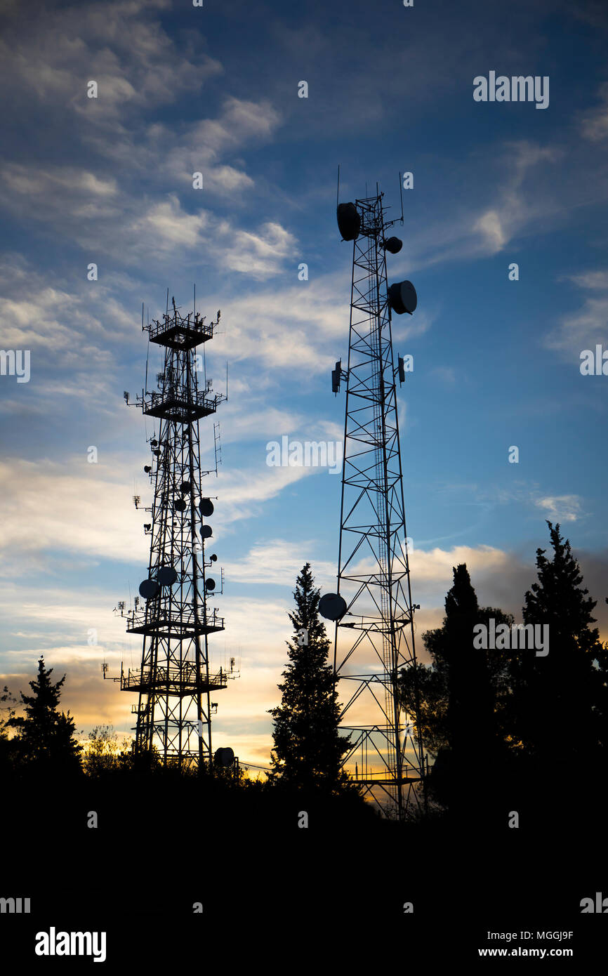 Silhouettes de deux antennes de communication dans une forêt à l'aube Banque D'Images