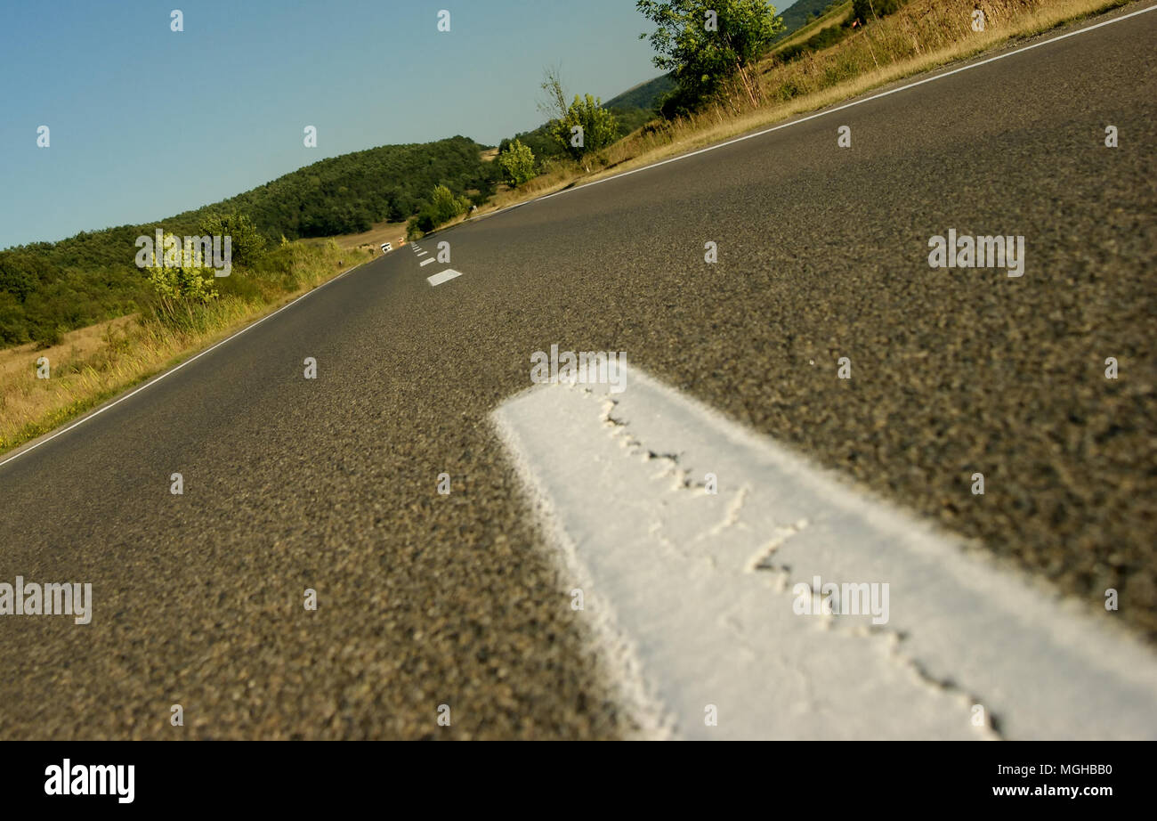 Les voitures très lointain qui arrive sur une route asphaltée Banque D'Images