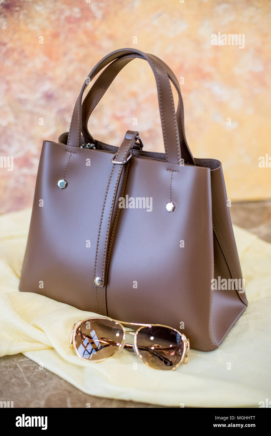 Accessoires Femme isolé sur fond jaune.Sac en cuir et des lunettes de  soleil.beau sac à bandoulière brun et des lunettes de soleil Photo Stock -  Alamy