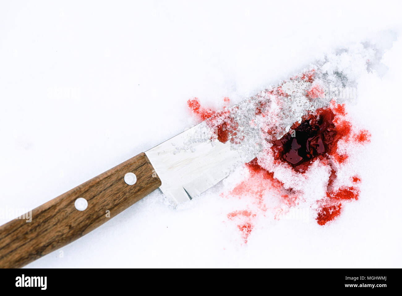 Couteau de cuisine en métal pointu utilisé comme arme du crime violent avec du sang tombe sur un fond blanc de la neige. Blade couverts dans la violence with copy space Banque D'Images
