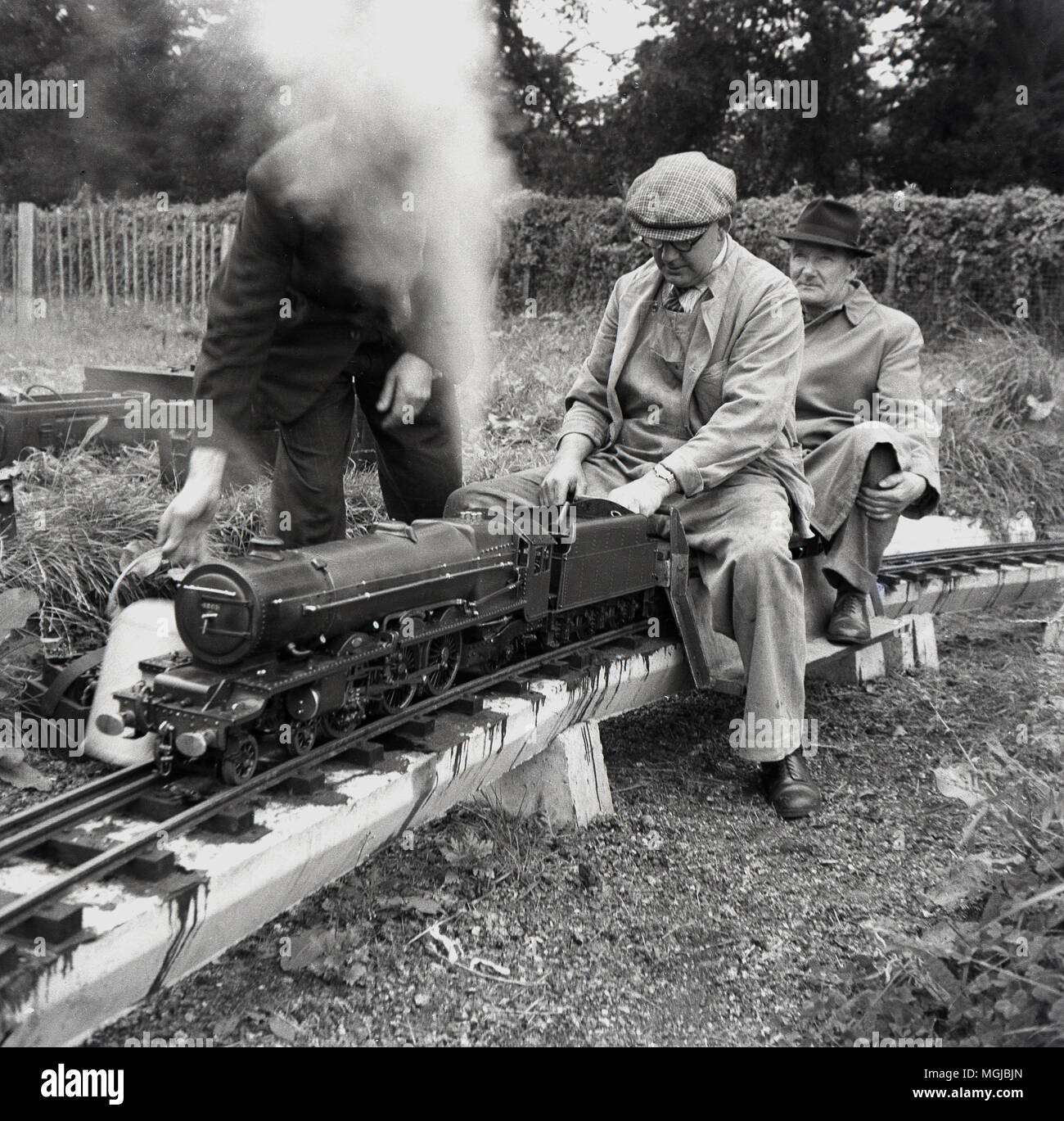 Années 1950, historiques, amteur mâles adultes amateurs de chemin de fer avec un train à vapeur sur un chemin de fer miniature, England, UK. Banque D'Images