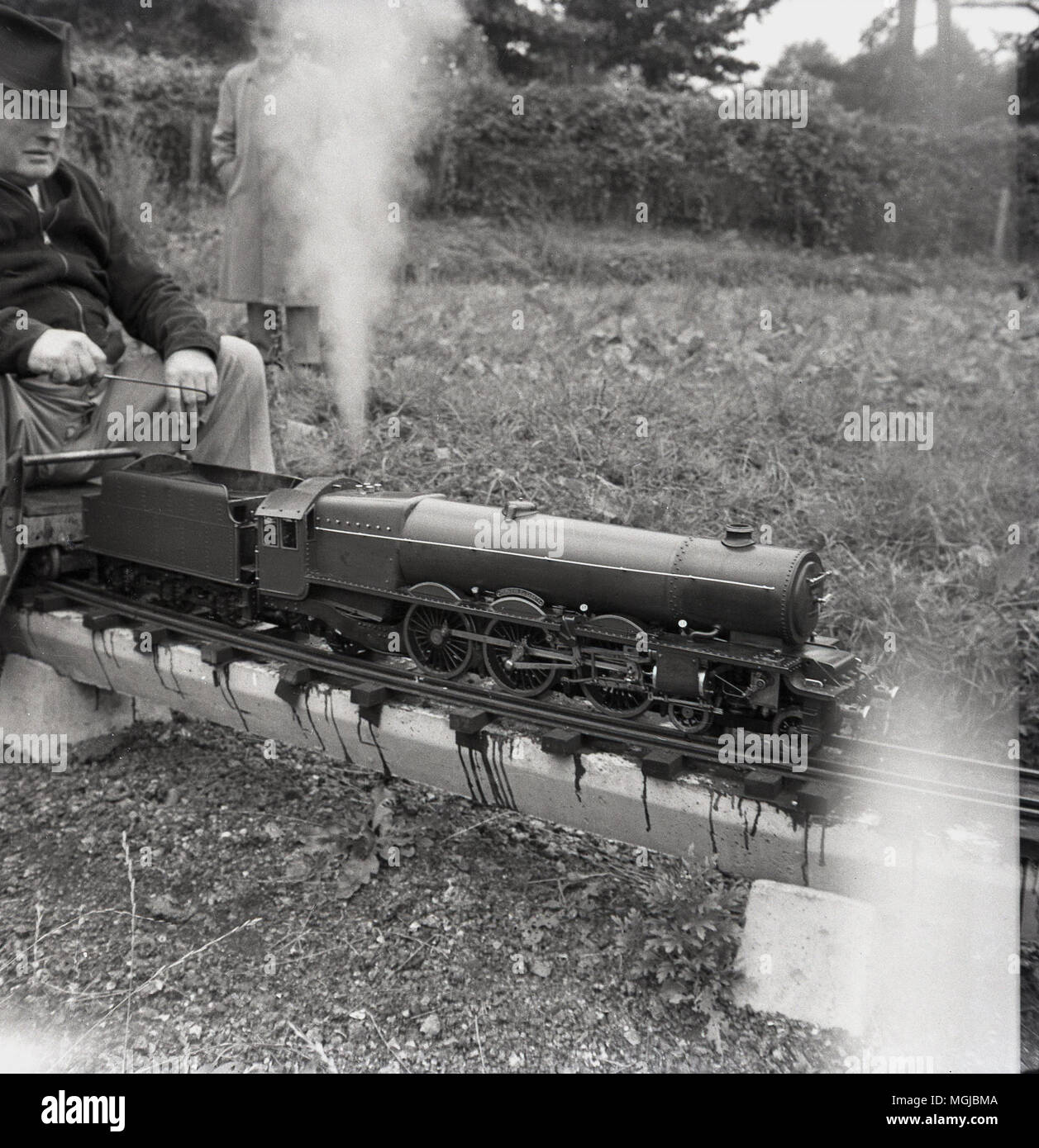 Années 1950, historiques, amteur mâles adultes amateurs de chemin de fer avec un train à vapeur sur un chemin de fer miniature, England, UK. Banque D'Images