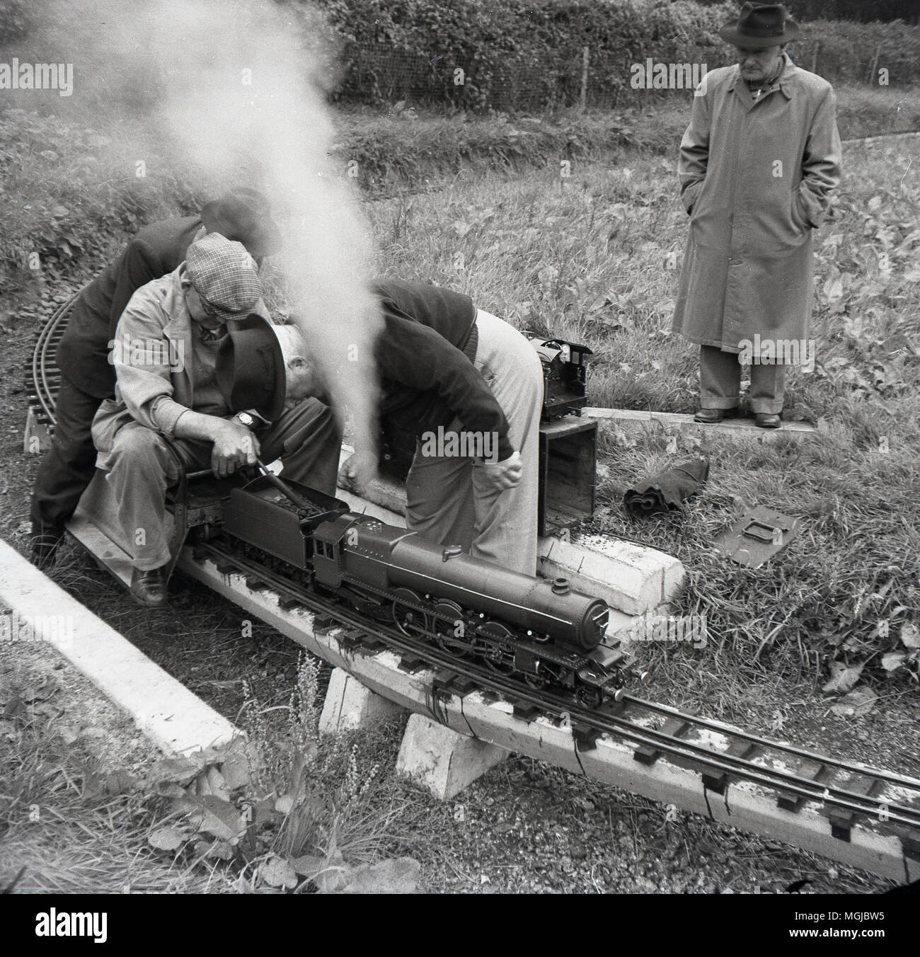 Années 1950, historiques, amteur mâles adultes amateurs de chemin de fer avec un train à vapeur sur un chemin de fer miniature, England, UK. Banque D'Images