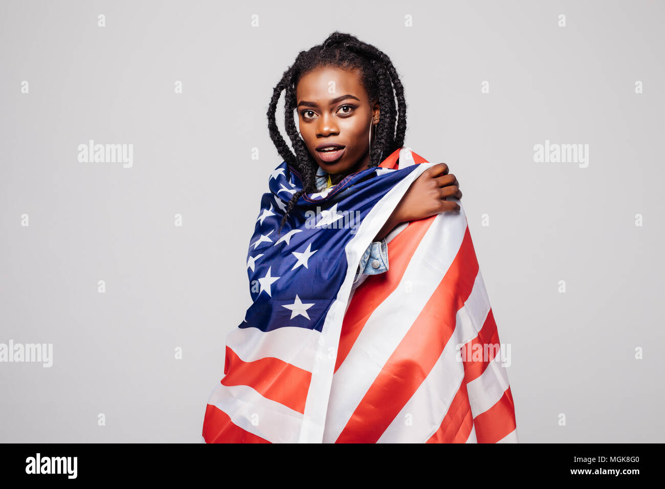 Smiling afro american woman holding USA drapeau et à la caméra à l'arrière-plan gris plus isolés Banque D'Images