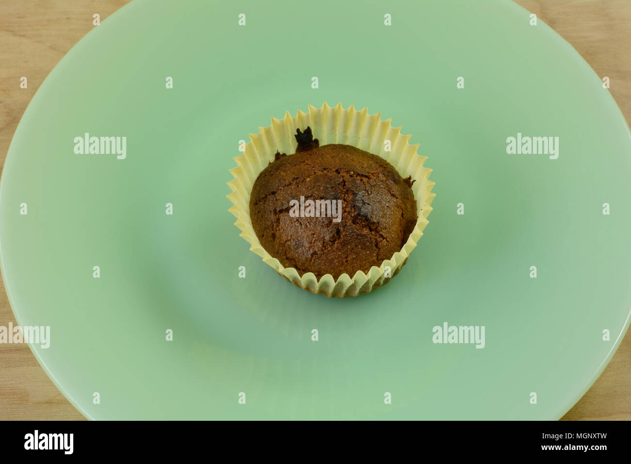 Un muffin à la semoule brûlées en coupe du muffin en papier sur la plaque verte Banque D'Images