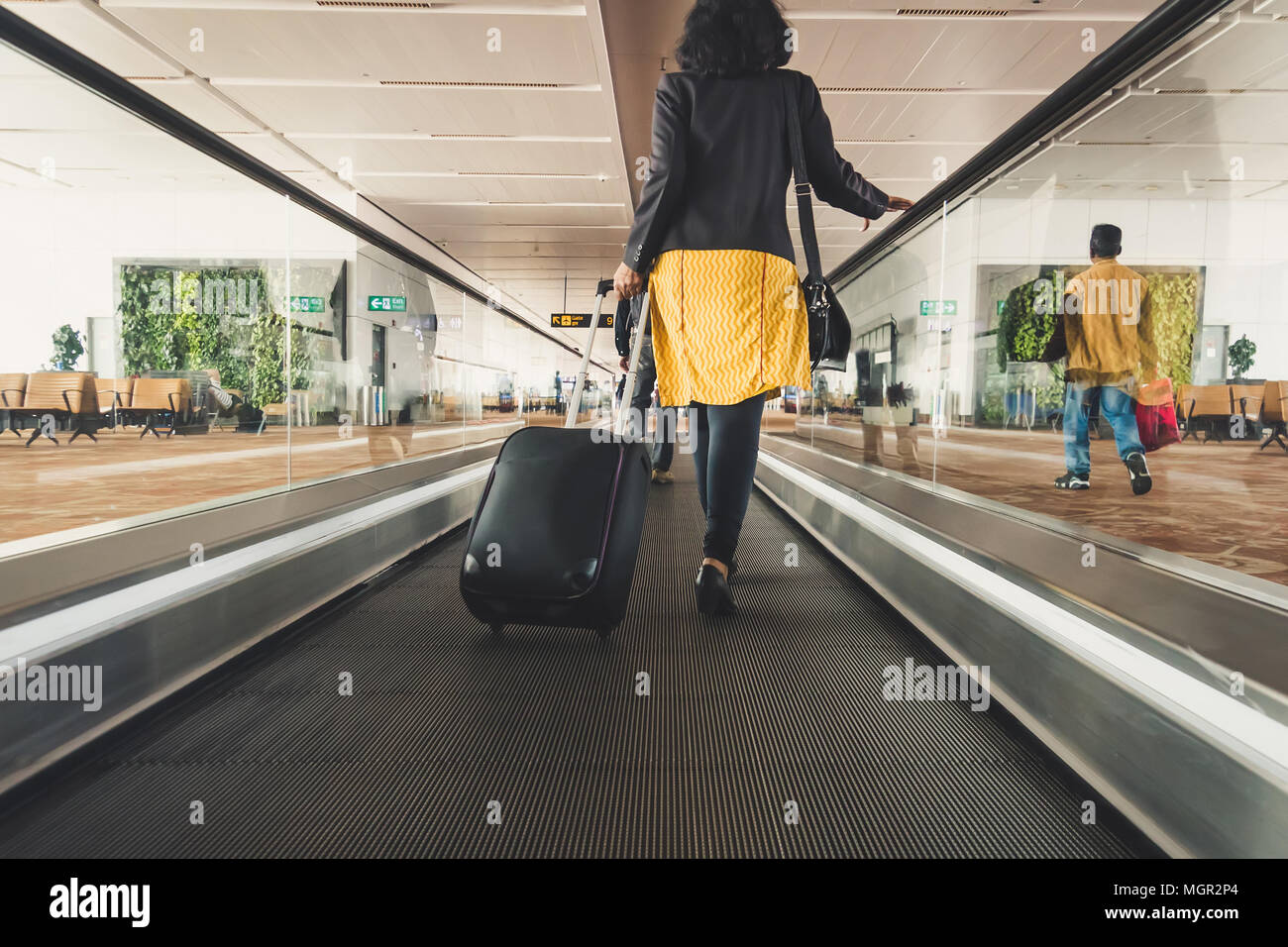Jeune fille traveler walking avec exécution tenir valise dans l'aéroport. Banque D'Images
