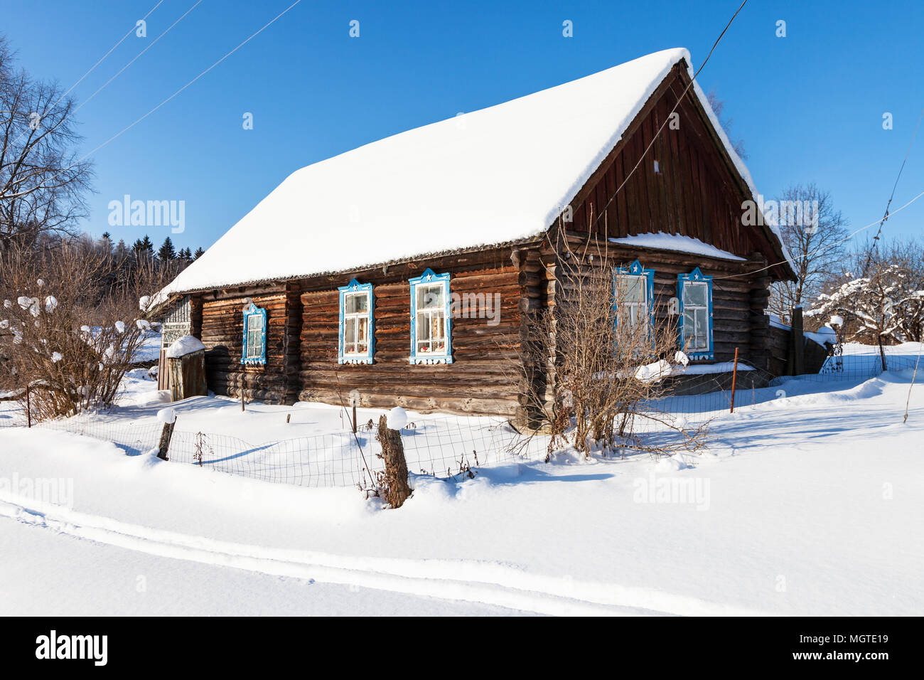 Ancienne maison rurale typiquement russe dans la journée d'hiver ensoleillée dans petit village dans la région de Smolensk Banque D'Images