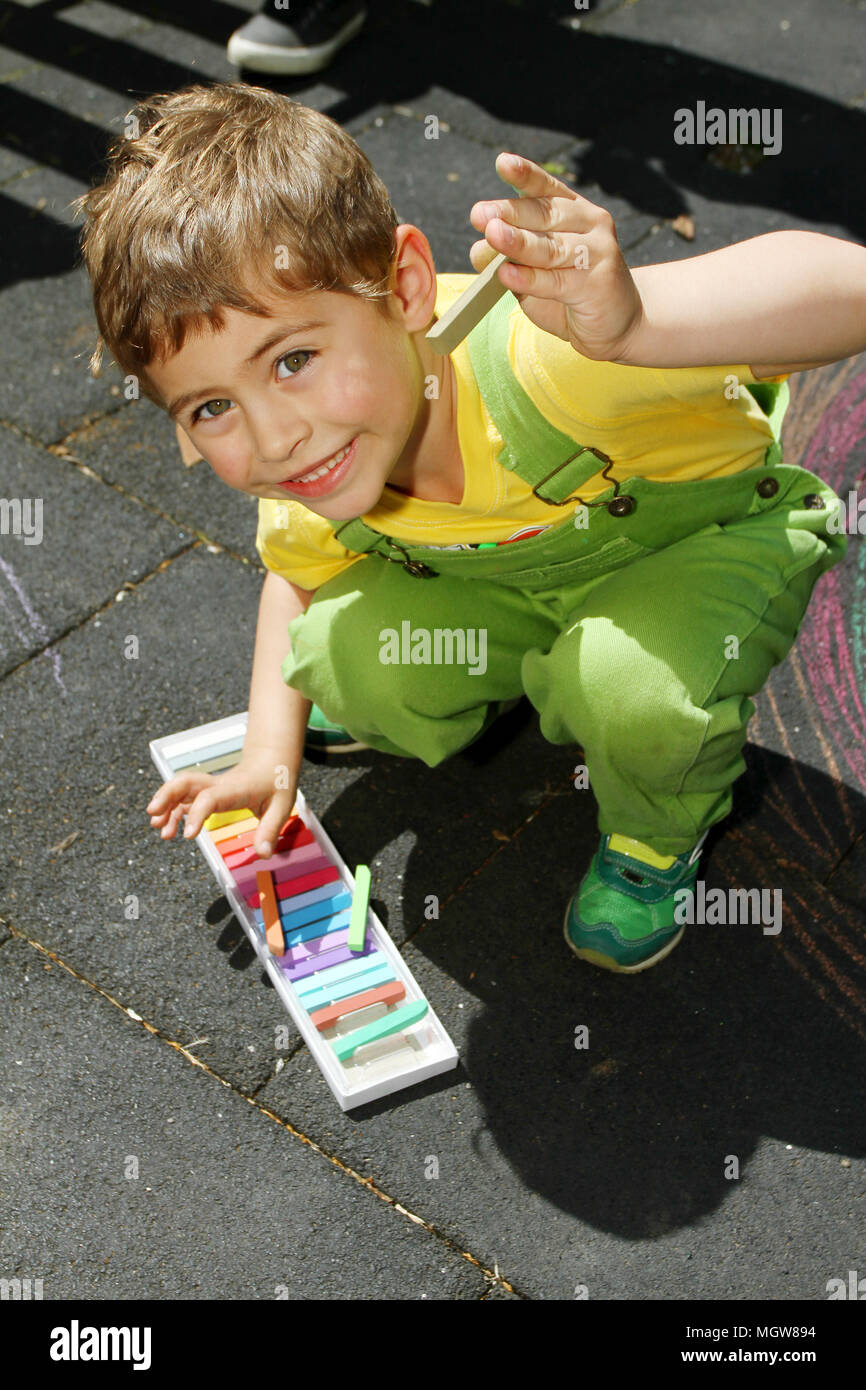 Cute boy nulles avec les craies colorées sur l'asphalte. L'activité d'été et des jeux créatifs pour les petits enfants. Enfant ensemble à s'amuser. L'école et vacances . Banque D'Images