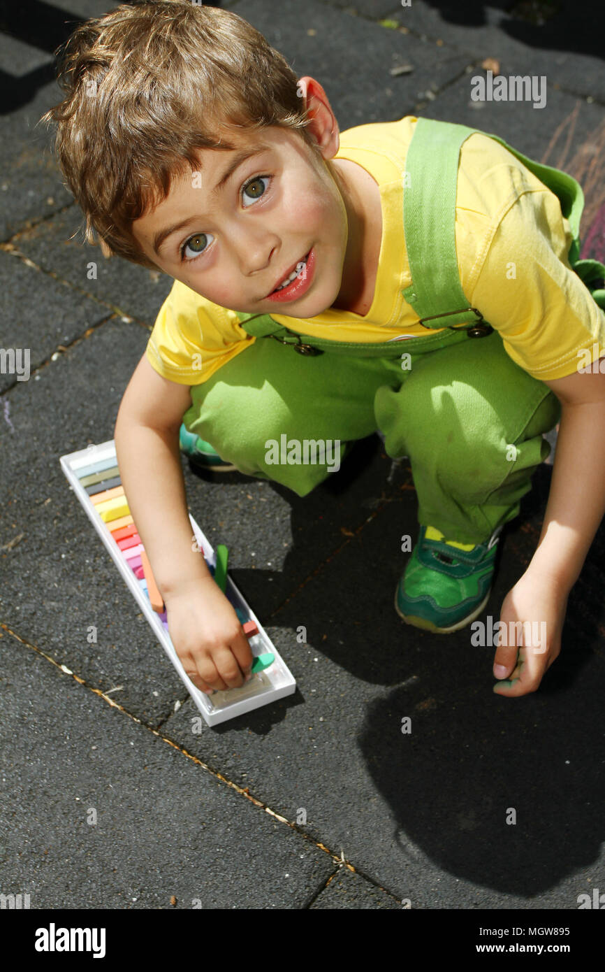 Cute boy nulles avec les craies colorées sur l'asphalte. L'activité d'été et des jeux créatifs pour les petits enfants. Enfant ensemble à s'amuser. L'école et vacances . Banque D'Images