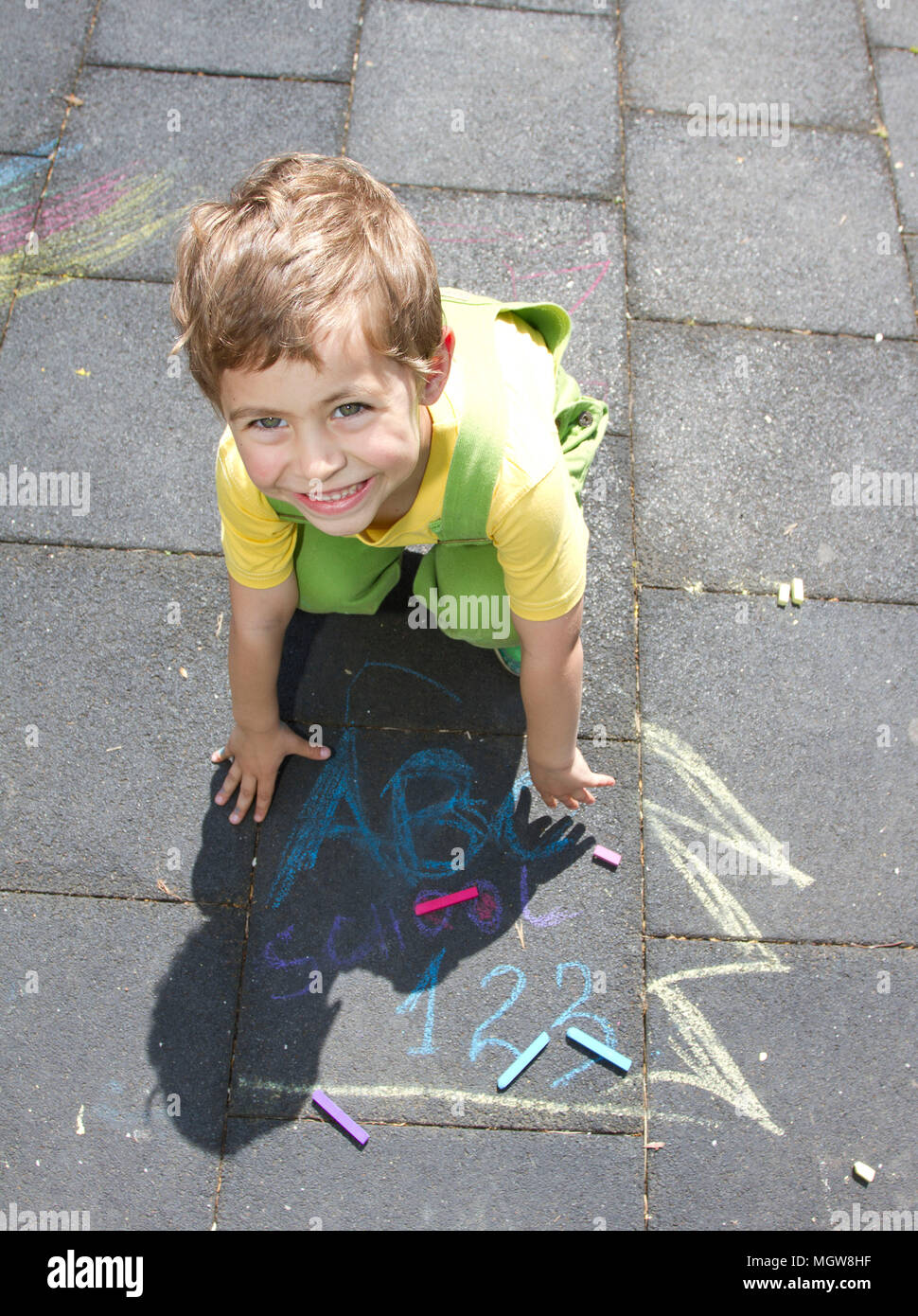 Cute boy écrire avec des craies de couleur. Petit enfant dessine avec des craies. L'école, et l'ABC 123 craies de couleur soupir écrit avec. Locations de concept. L'éducation. Banque D'Images