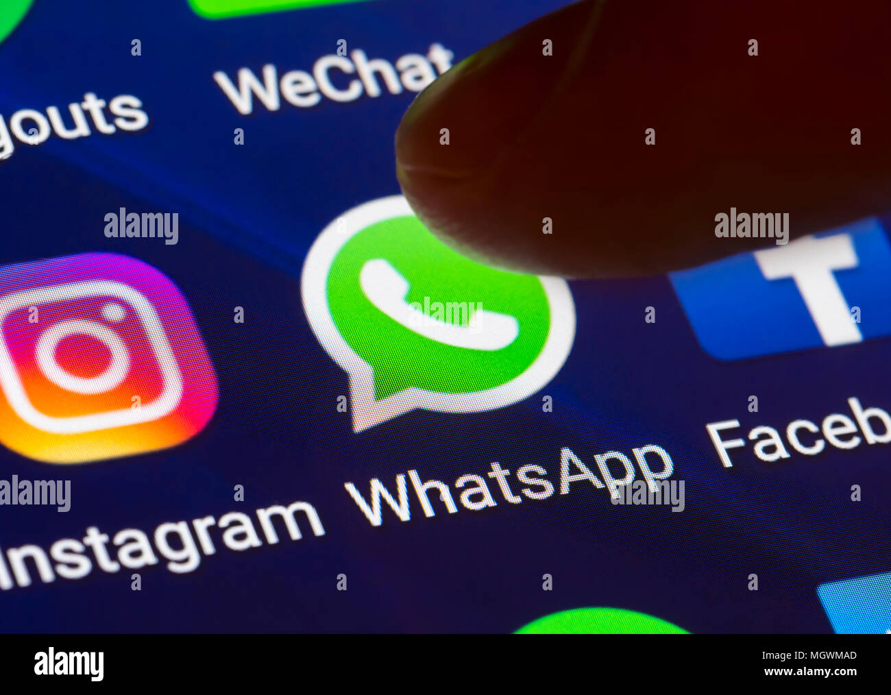 Icône Whatsapp. Doigt qui appuie sur une icône de raccourci pour charger l'application WhatsApp sur une tablette ou smartphone écran. Bouton de Whatsapp. Banque D'Images