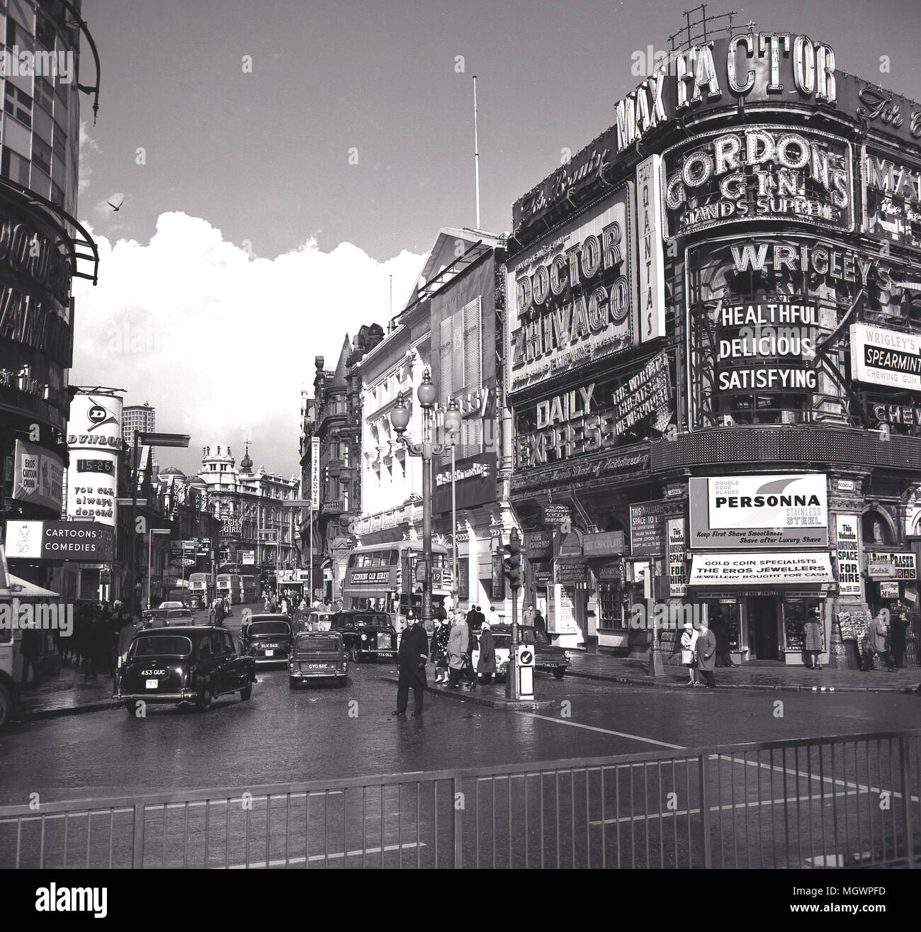 1966, photo historique montrant une vue sur Shaftesbury Avenue jusqu'à Piccadilly Circus, avec les panneaux publicitaires pour des grandes marques, Max Factor, Wrigley's et le Daily Express. Le film est annoncé également, Docteur Jivago fixant Omar Sharif et Julie Christie et réalisé par David Lean, Londres, Angleterre, Royaume-Uni. Banque D'Images
