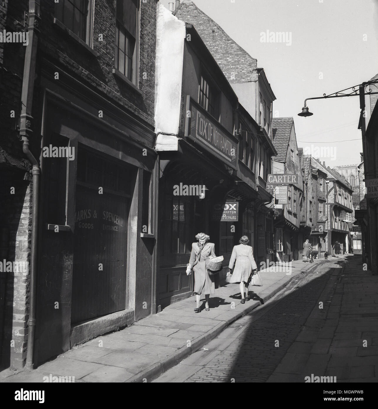 Années 1950, tableau historique de "la pagaille" à York, Angleterre, Royaume-Uni, une ancienne cité médiévale rue pavées étroites bordées d'anciennes en surplomb bâtiments à pans de bois et célèbre pour les boucheries (25 en 1872) qui ont utilisé au commerce le long de celle-ci au 19e siècle. En effet, le mot 'shambles' est un vieux terme pour l'abattoir. Banque D'Images