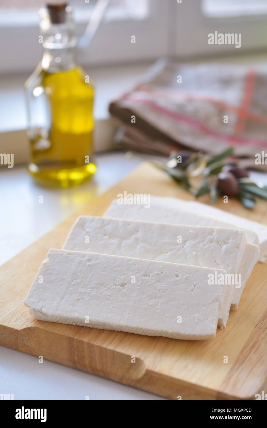 Le fromage Feta sur une planche à découper à l'olives et huile d'olive Banque D'Images