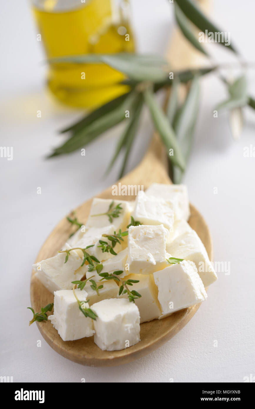 Fromage feta coupé en dés dans une cuillère en bois contre l'huile d'olive Banque D'Images