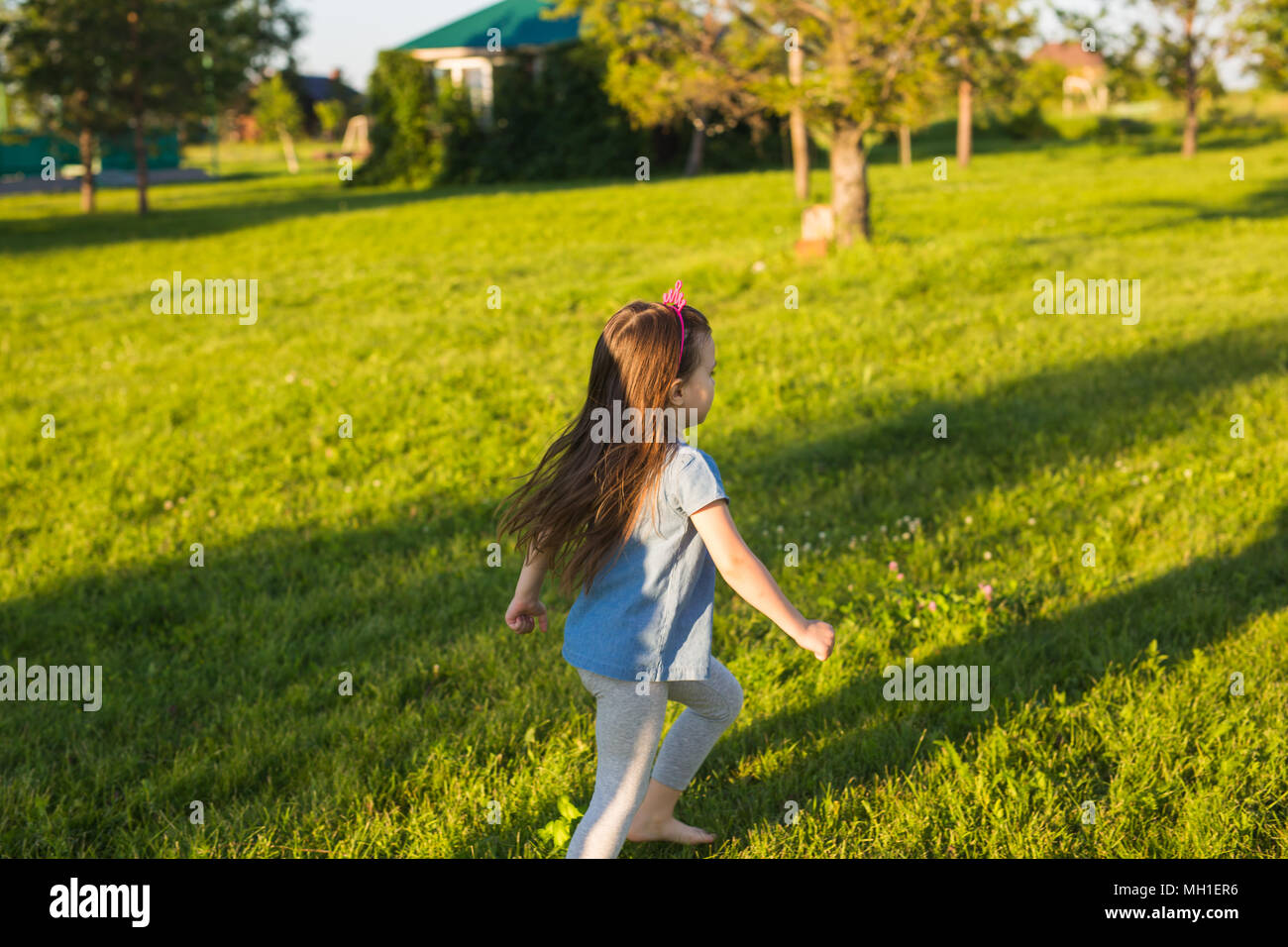 Heureux l'enfant s'exécute en parc d'été Banque D'Images