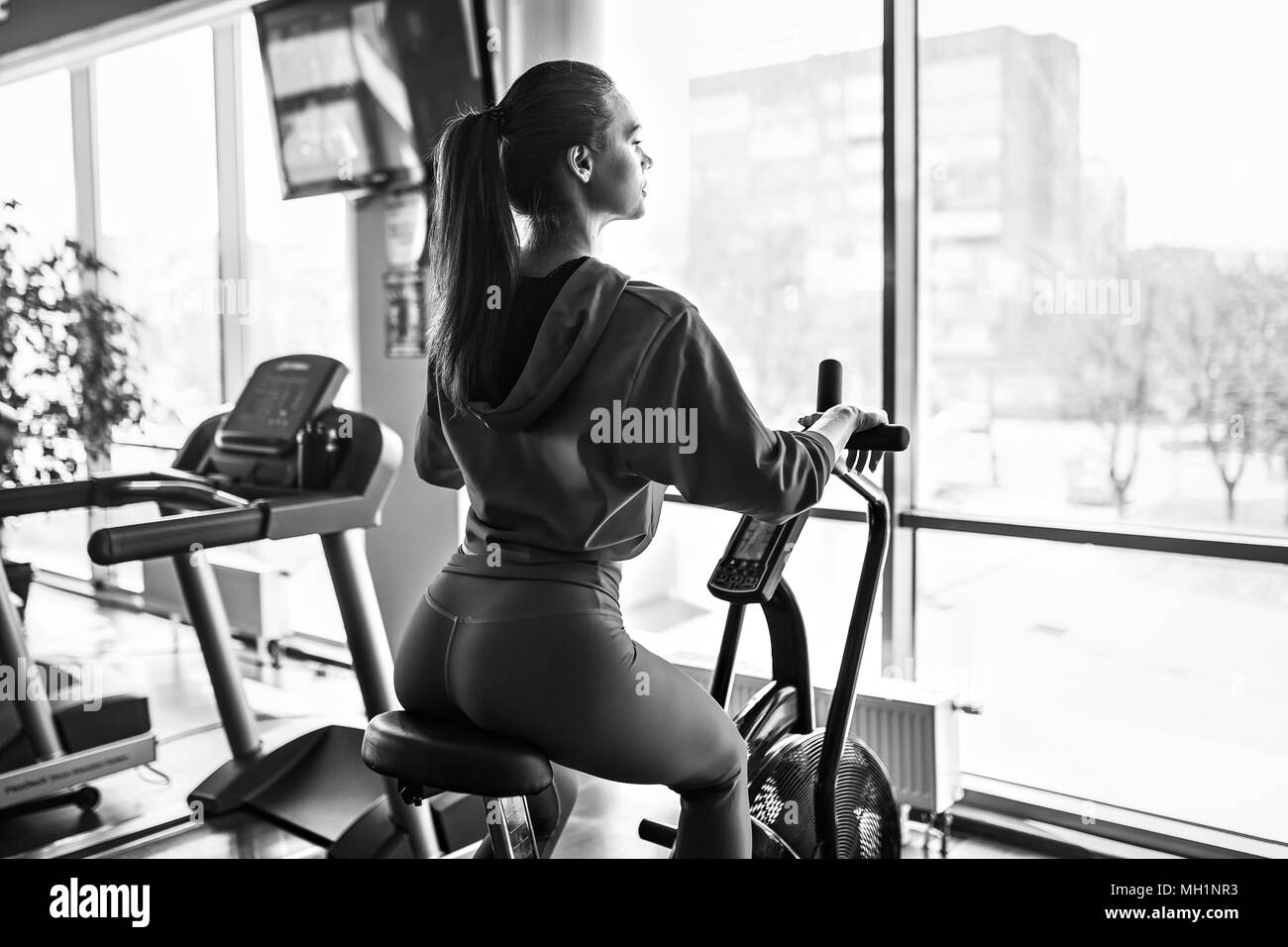 Femme de remise en forme de l'air à l'aide de vélo pour entraînement cardio à la salle de sport. Banque D'Images