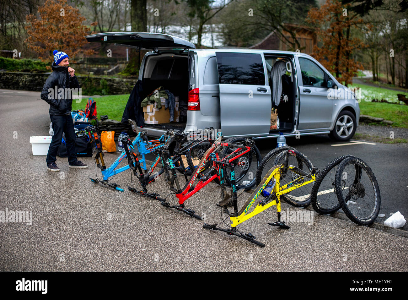 Deux hommes déballage des vtt à une Mercedes Vito van dans un parking à Grizedale dans le Lake District. Banque D'Images