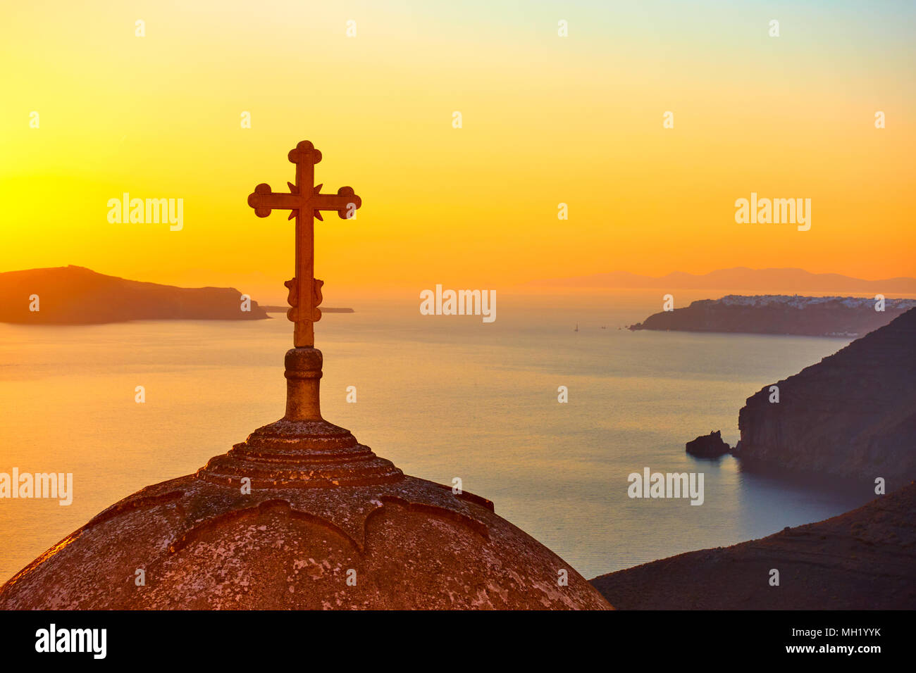 Le dôme avec croix d'une église orthodoxe grecque à Thira town sur l'île de Santorin au coucher du soleil, la Grèce Banque D'Images