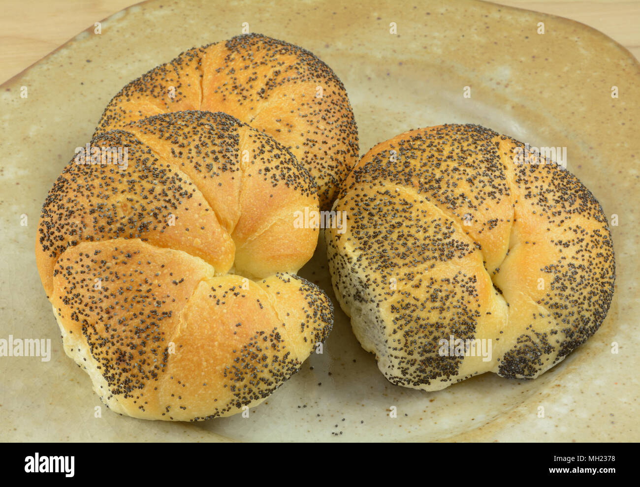 Trois graines de pavot frais croissants bagel figurant sur brown plaque en céramique pour le petit déjeuner ou pour faire des sandwichs pour le déjeuner Banque D'Images