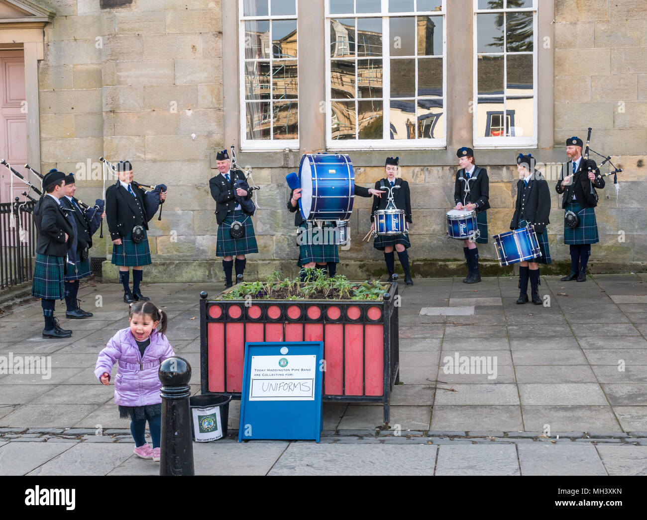 Jeune enfant donnant don à Haddington Pipe Band, Corn Exchange, Place d'Aubigny, Court Street, East Lothian, Scotland, UK Banque D'Images