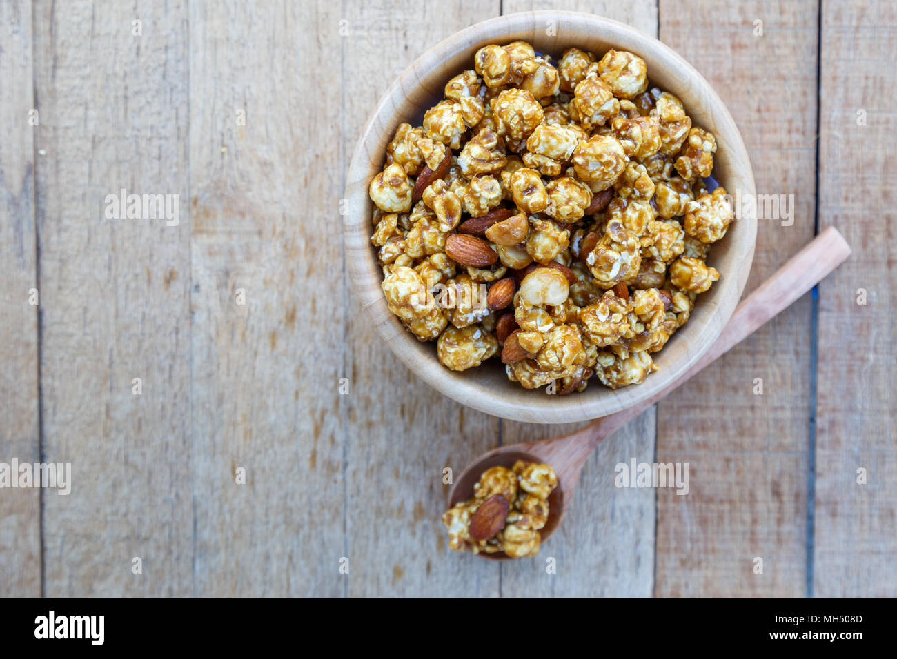 Mélange de caramel et de macadamia Popcorn goût amande sur table en bois avec copie espace. vue d'en haut. Banque D'Images