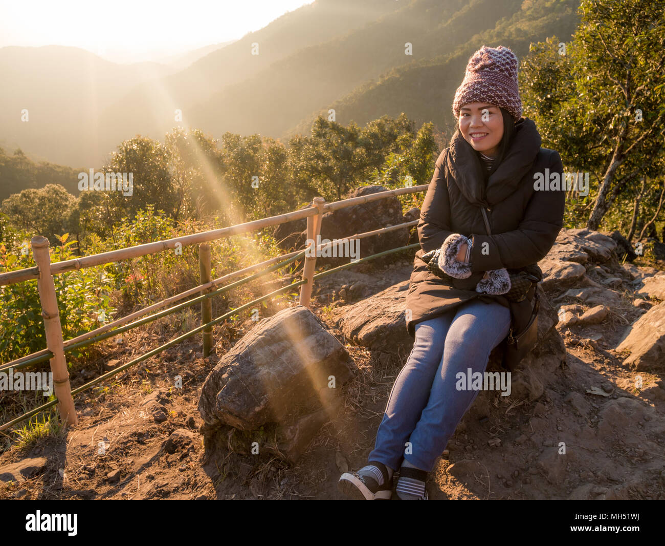 Fille de l'Asie Moyen-âge heureux en montagne il moment du lever ou du coucher du soleil avec l'exemplaire de l'espace. Banque D'Images