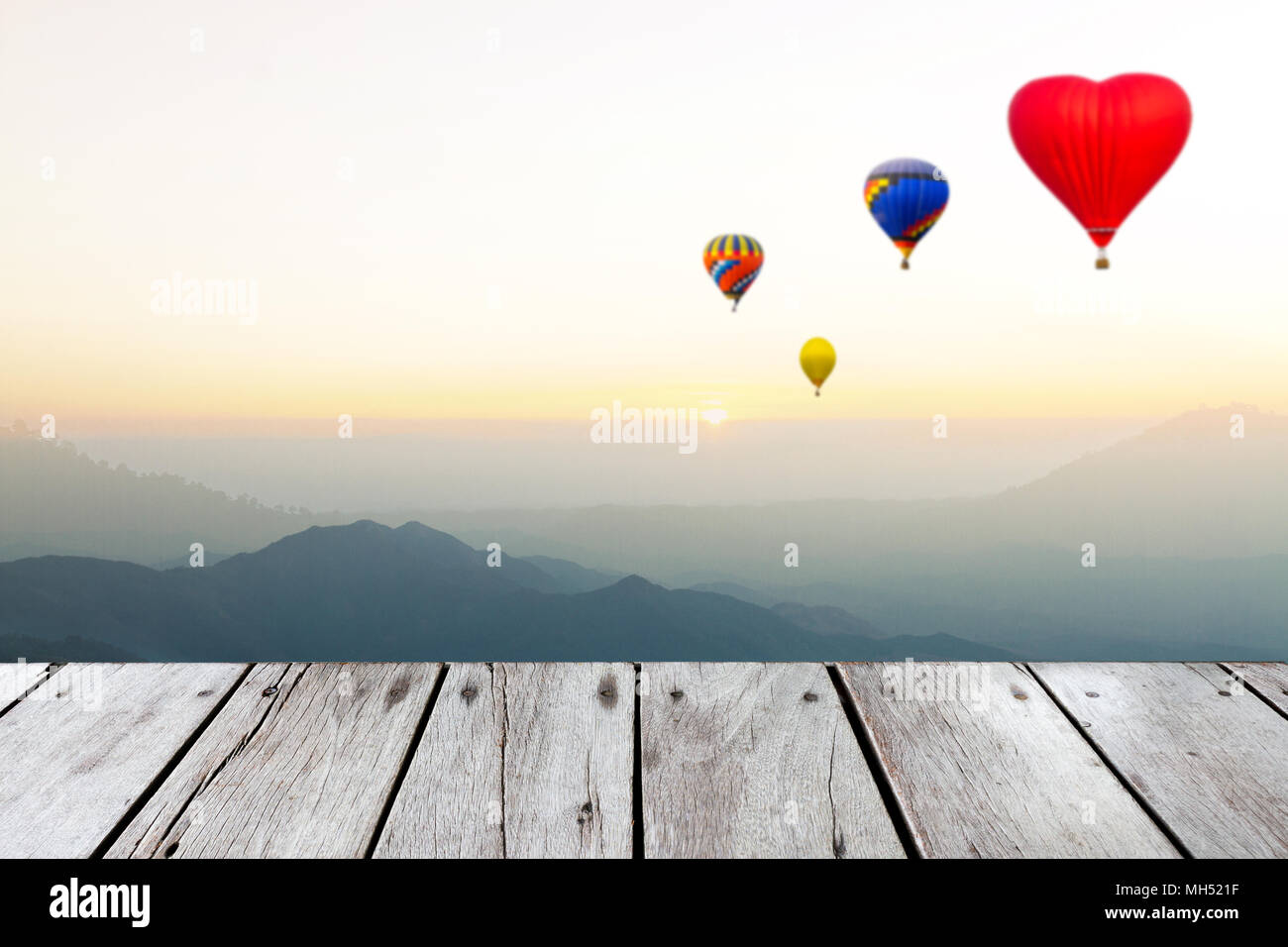 Les ballons volent sur la montagne, au coucher du soleil ou l'heure de lever et de planche en bois avec l'exemplaire de l'espace. Ce concept photo. Banque D'Images