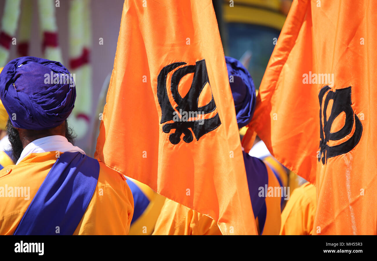 Symbole de la religion Sikh appelé KHANDA constitué par deux cimeterres sur les drapeaux orange et l'homme avec le turban bleu Banque D'Images