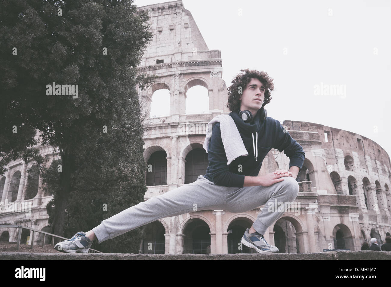 Beau jeune sportif l'étirement et l'échauffement pour la formation à l'avant du Colisée à Rome Banque D'Images