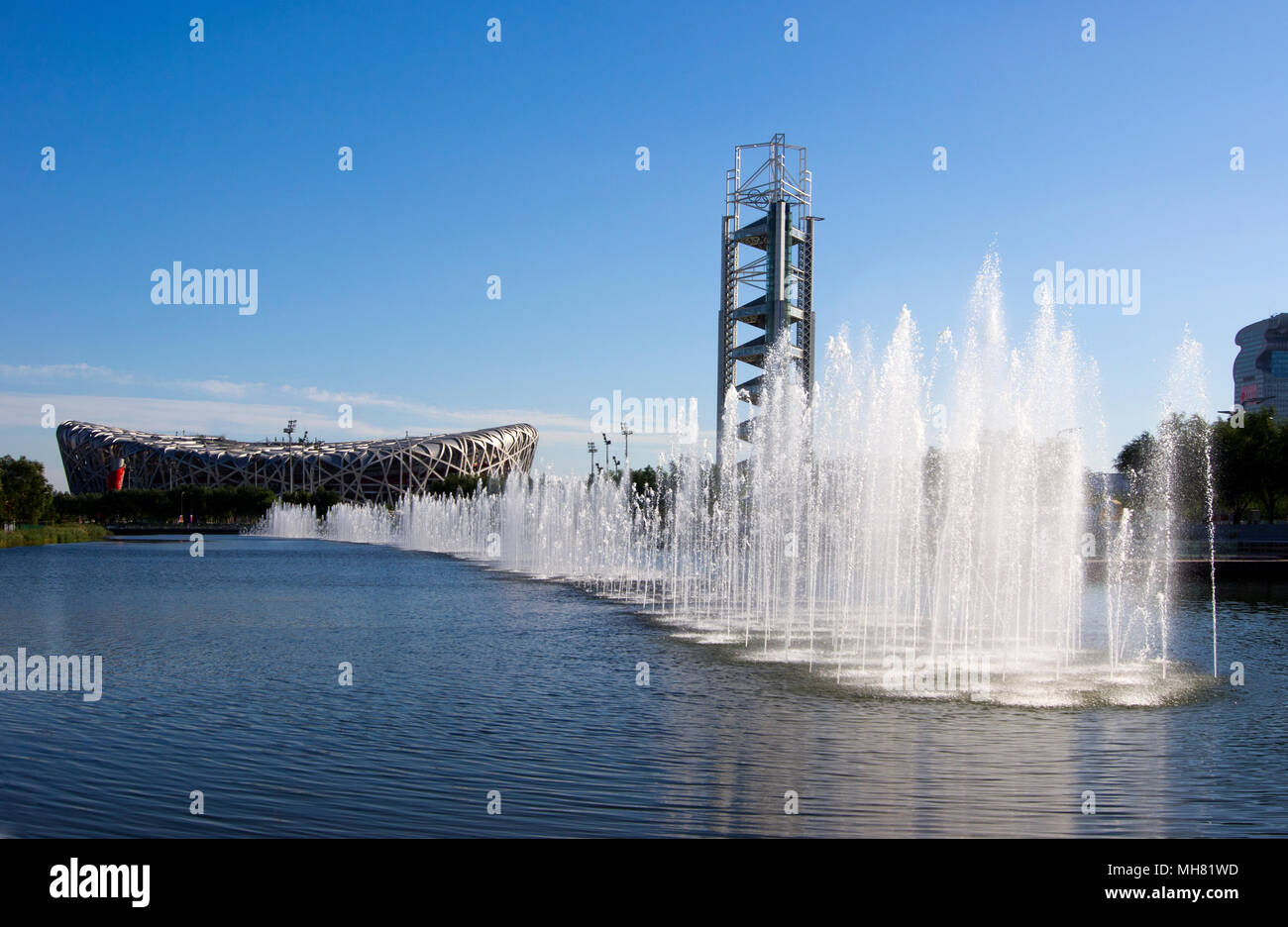 La pièce d'eau, avec des fontaines, dans le Parc olympique de Beijing, Chine. Le Nid d'oiseau stadium est visible à gauche et la Tour China olympique. Banque D'Images