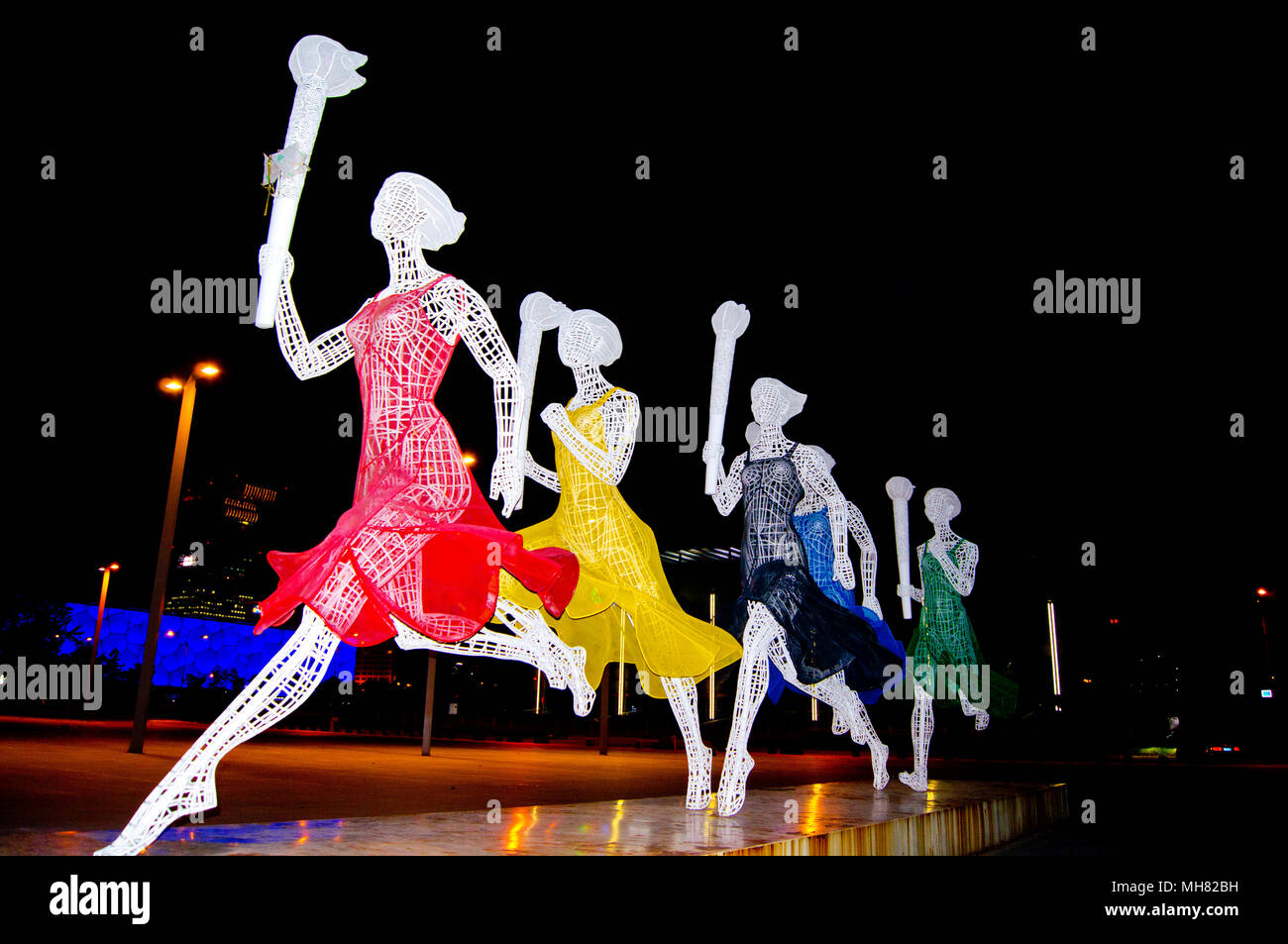Relais de la flamme olympique de Beijing sculpture, photographié de nuit. Cette œuvre d'art public dans le parc olympique, Beijing, Chine, comprend cinq dames. Banque D'Images