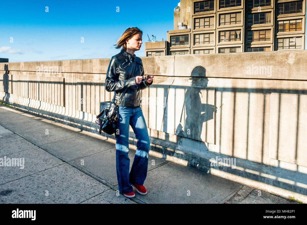 Une jeune femme perdue dans ses pensées fait son chemin à travers le pont Harbour Bridge de Sydney à pied sur une journée ensoleillée à Sydney en Nouvelle-Galles du Sud. Banque D'Images