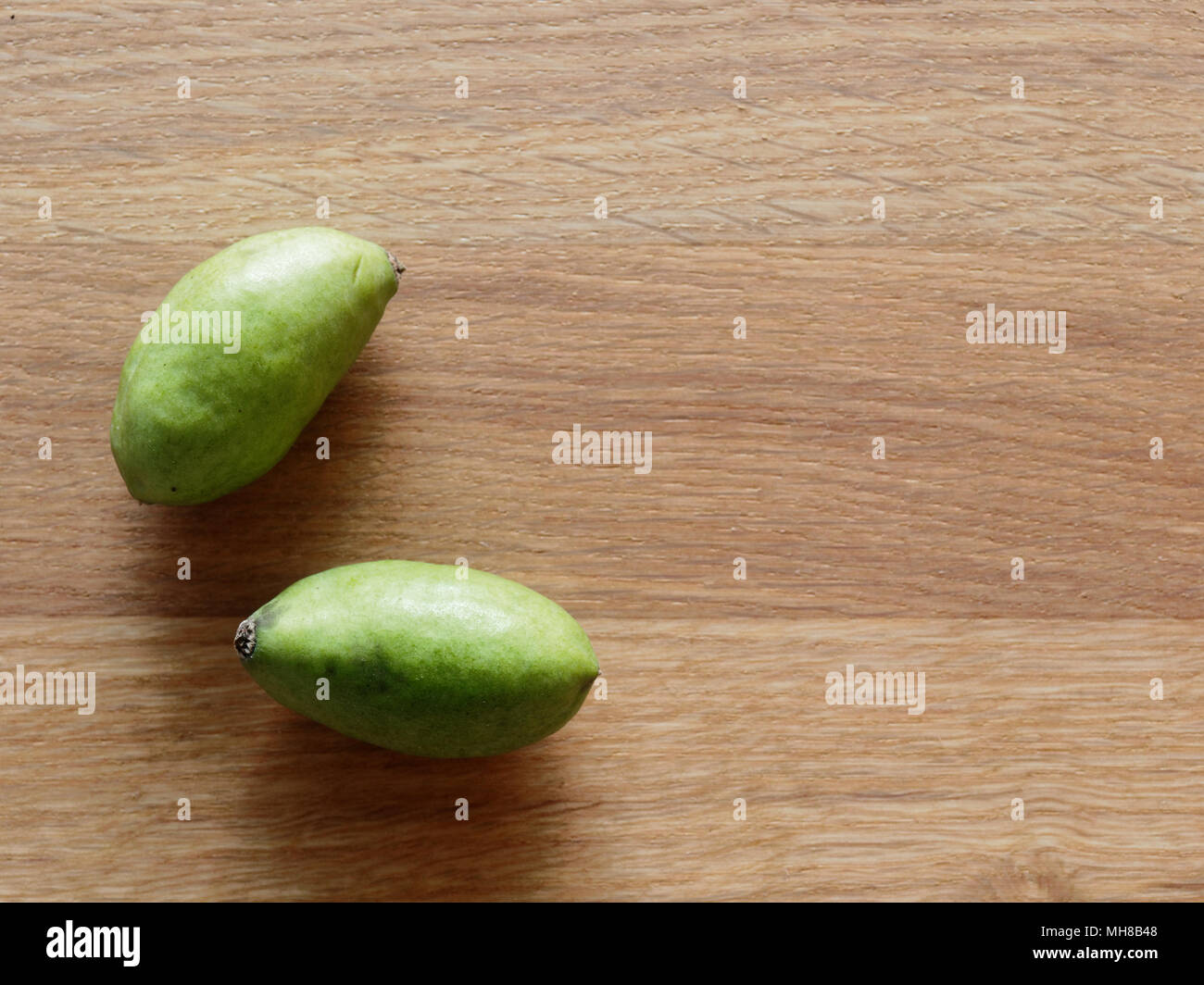 Un groupe de porcs fruits prunes vertes, qui ressemblent à de petits mangue, sur fond de bois clair avec des concepts de bien-être et de la santé comme ils sont riches en antioxydants naturels, vitamines et minéraux Banque D'Images