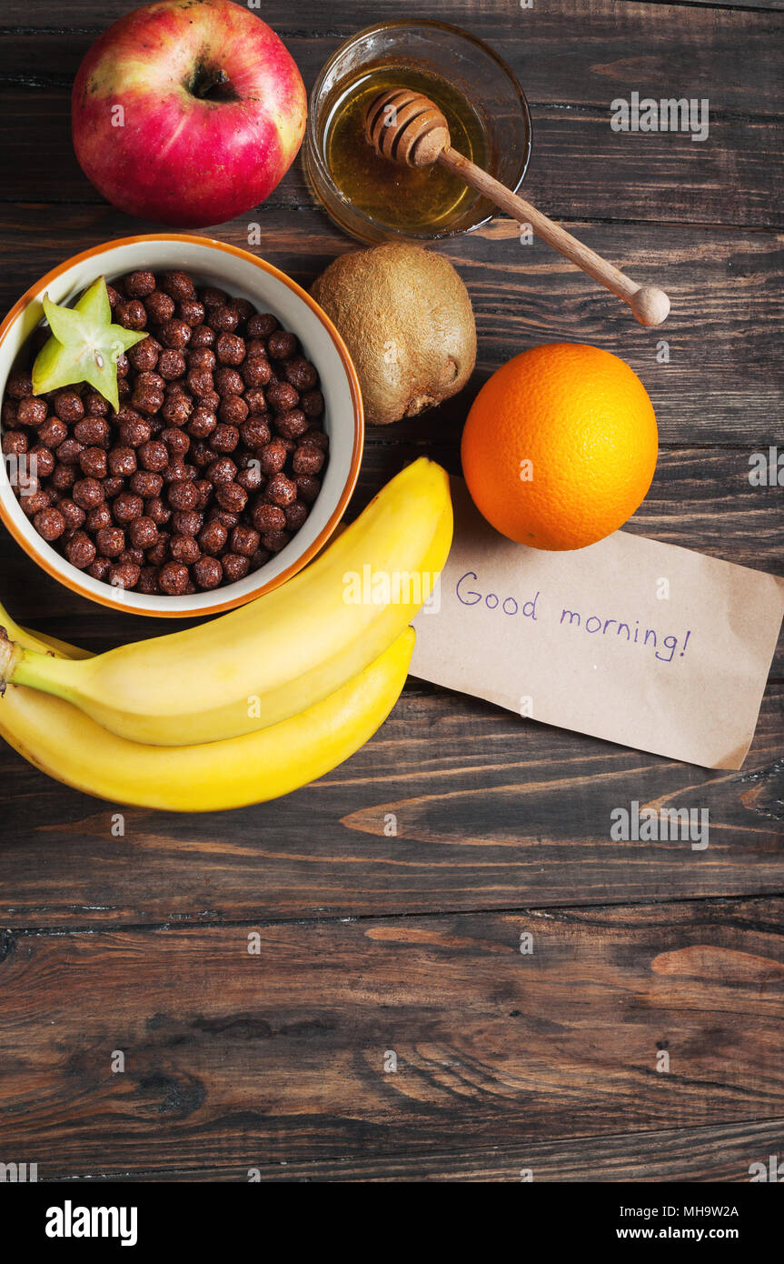 Petit-déjeuner sain - boules chocolat céréales et fruits sur fond de bois. Banque D'Images