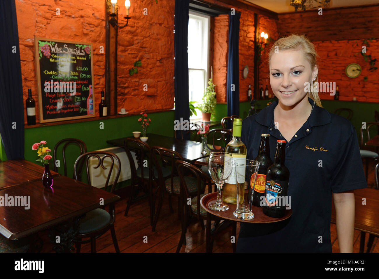 Serveuse en restaurant avec un plateau de verres de vin et bière Banque D'Images