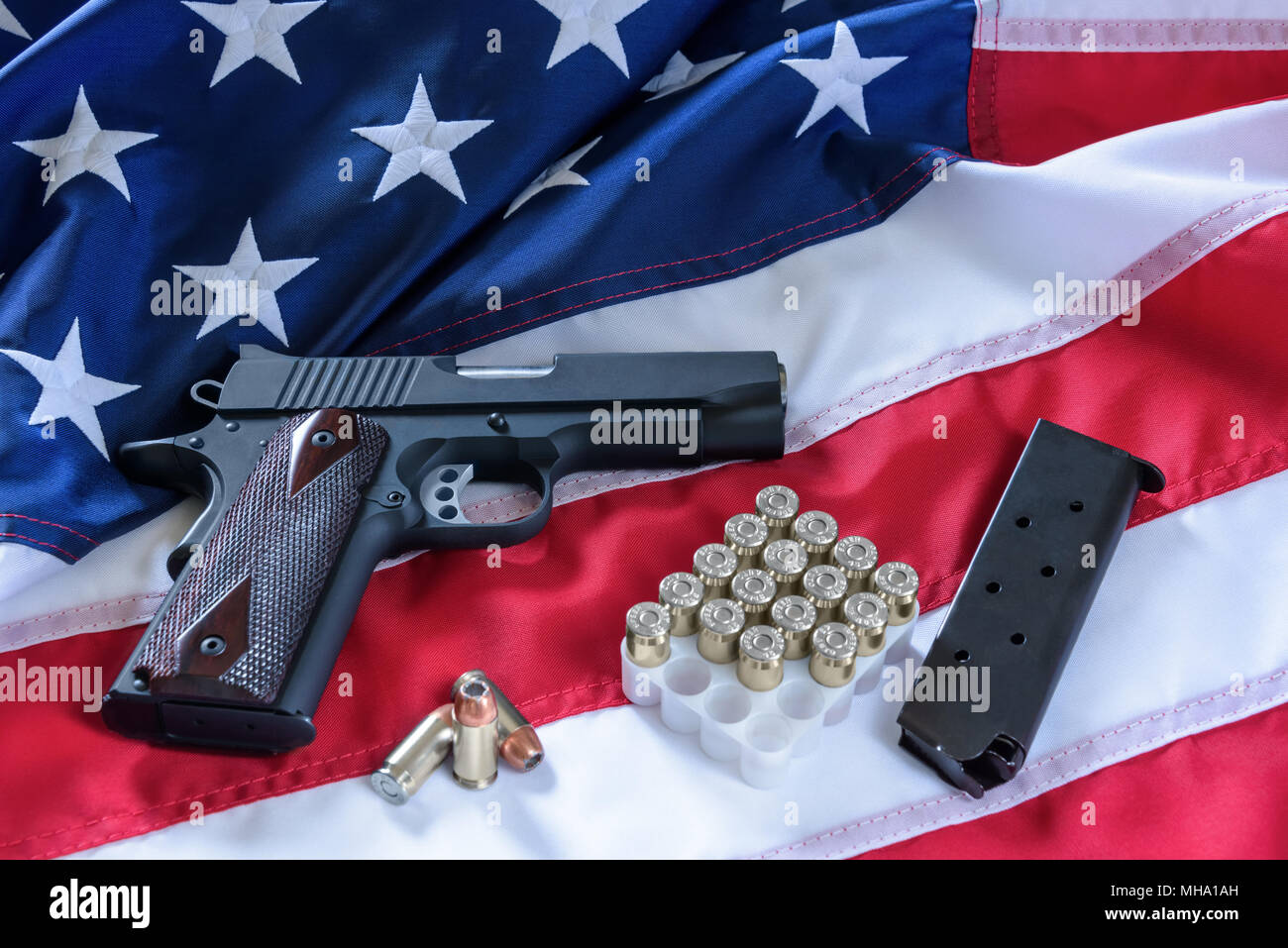 Le deuxième amendement et le contrôle des armes à feu aux États-Unis, concept. Une arme de poing, un magazine, des balles, et la constitution américaine sur le drapeau USA. Banque D'Images