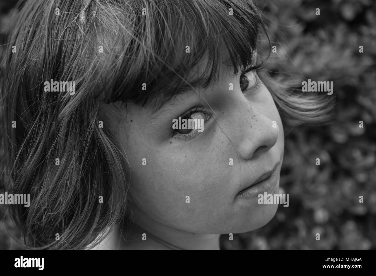 Le noir et blanc portrait d'une jeune fille à la Par-dessus son épaule Banque D'Images