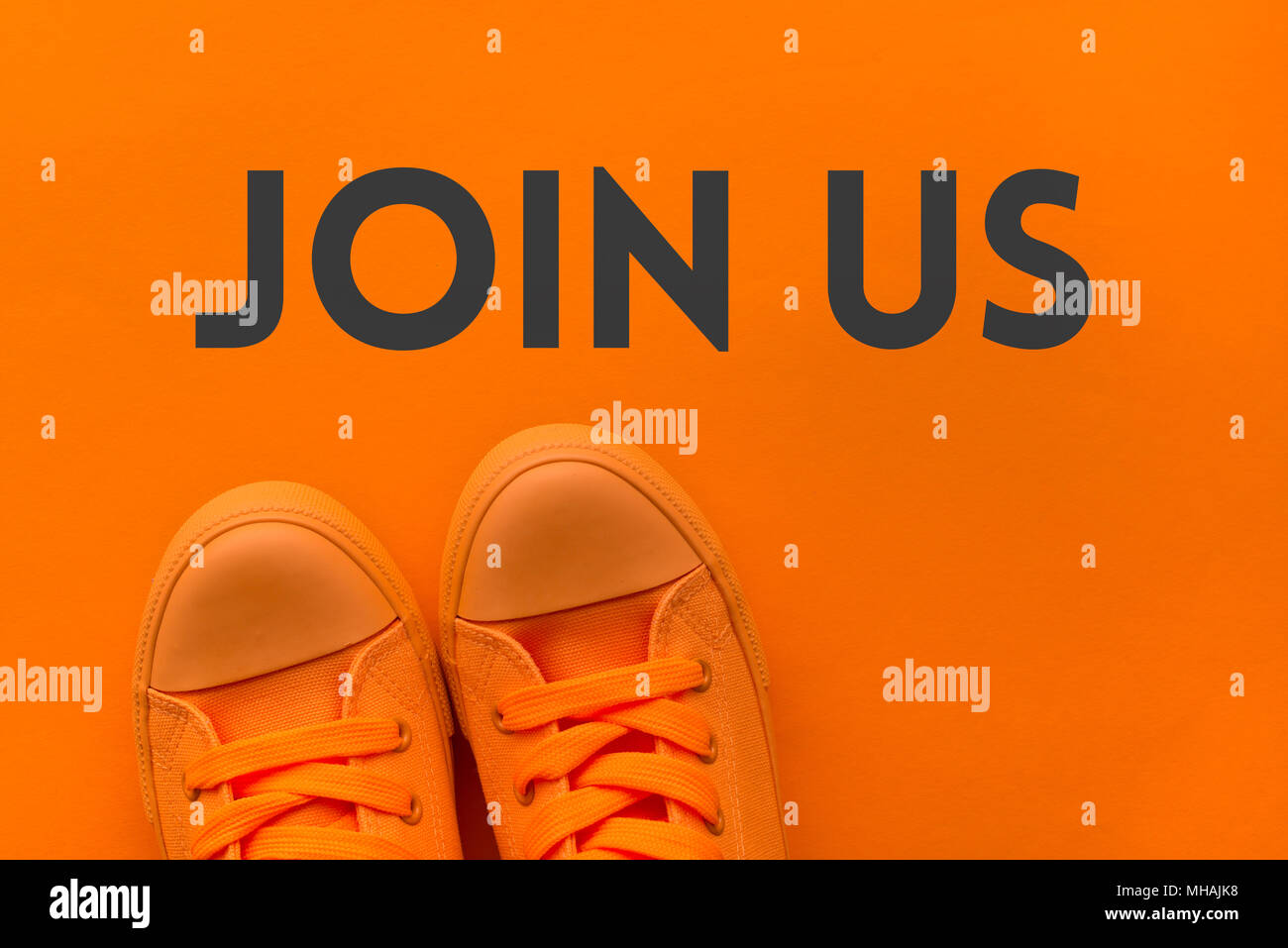 Rejoignez-nous invitation, jeune personne en orange sneakers debout sur le message texte, vue du dessus Banque D'Images