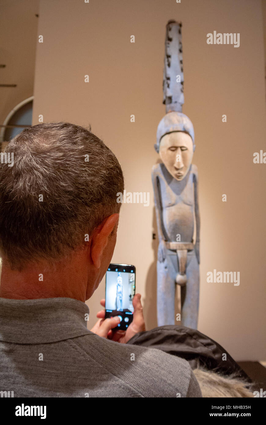 le touriste arrachant une statue d'art primitif en bois avec son téléphone mobile, musée du louvre, paris, france Banque D'Images