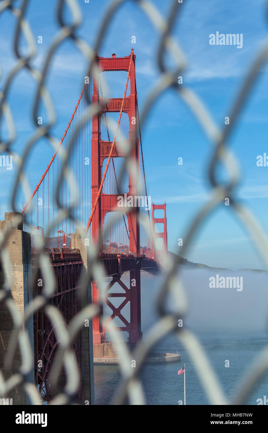 Vue sur le Golden Gate Bridge, avec le brouillard en dessous, à travers la barrière de sécurité, San Francisco, California, United States. Banque D'Images