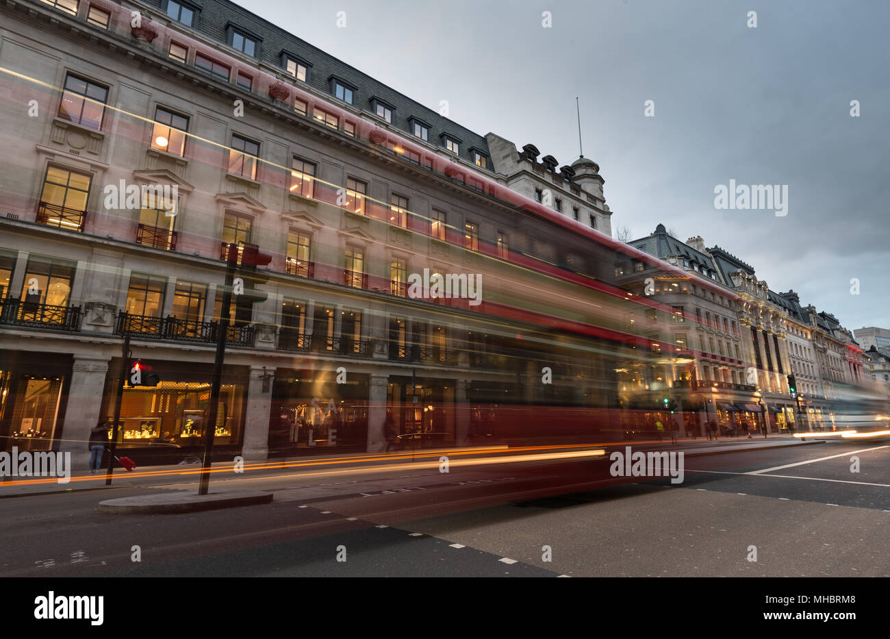 Les sentiers de la lumière d'un déménagement rapide red bus dans Regent Street, dans la city de Londres , Royaume-Uni. Banque D'Images