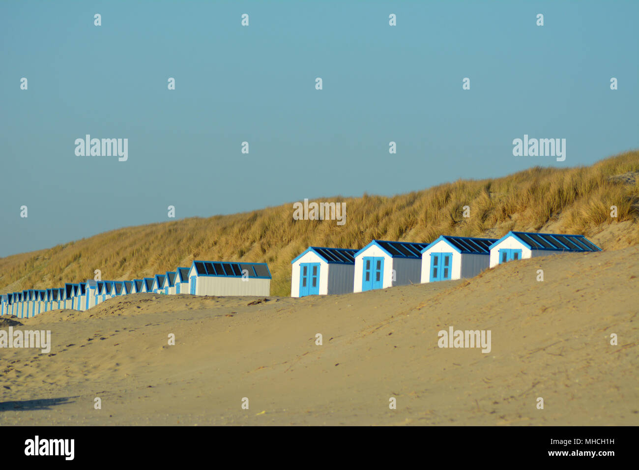 Peu de cabines de plage au coucher du soleil sur la mer du Nord sur waddeneiland Texel Hollande Europe. Banque D'Images