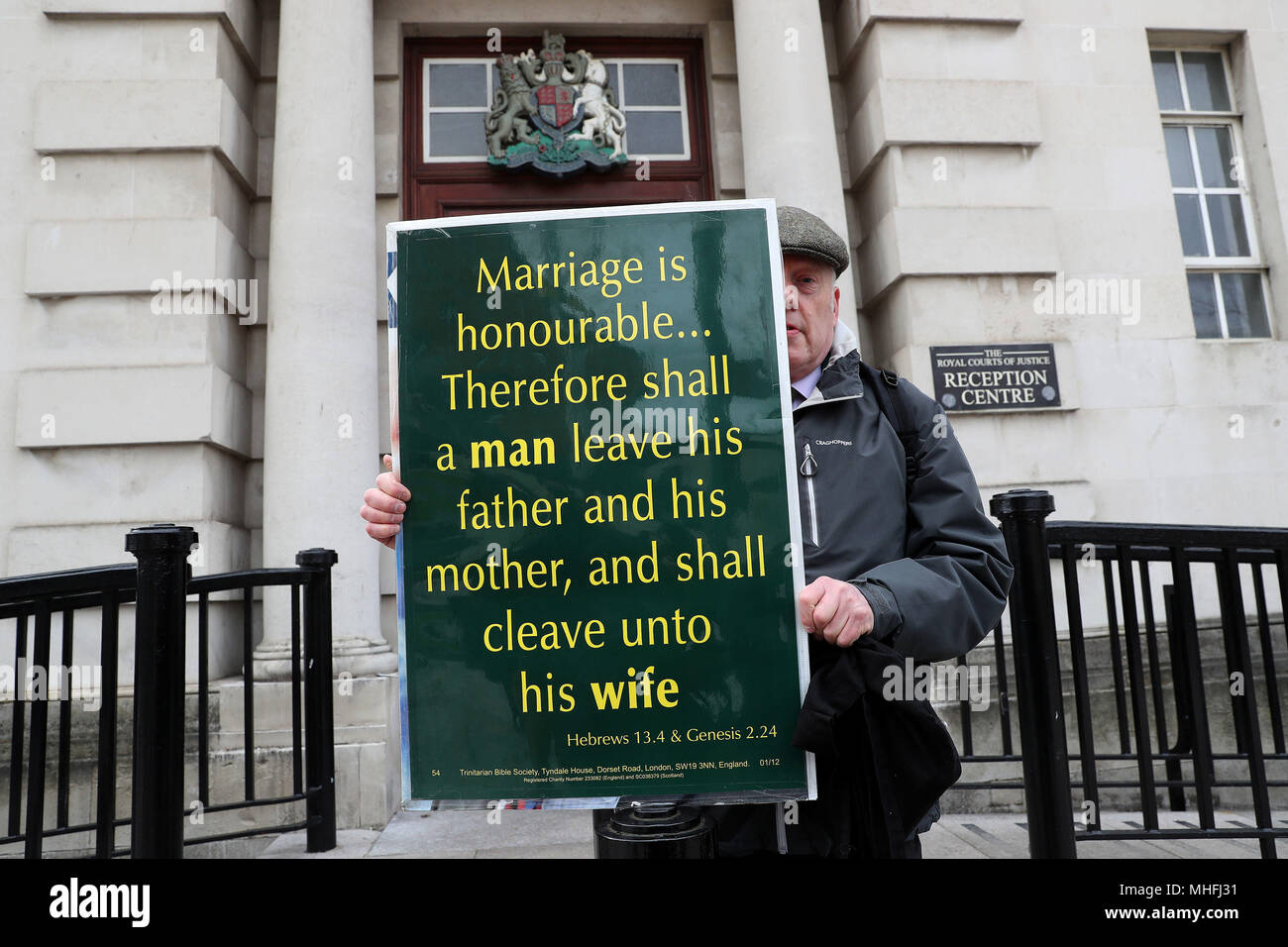 Un homme est titulaire d'une plaque-étiquette indiquant la Bible en dehors de la Royal Courts of Justice à Belfast où la Cour suprême examine les questions liées à l'Ashers Baking Company gâteau 'gay' cas. Photo date : mardi 1 mai 2018. Voir l'activité de l'ULSTER histoire gâteau. Crédit photo doit se lire : Brian Lawless/PA Wire Banque D'Images