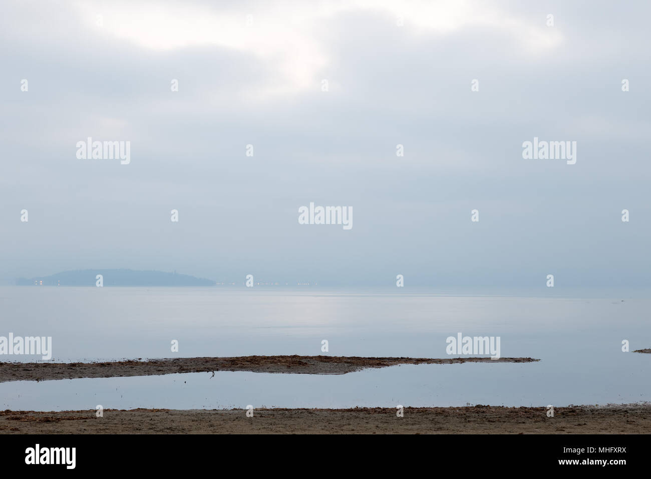 Vue du lac Trasimène minimaliste à l'aube de la rive avec des teintes douces Banque D'Images